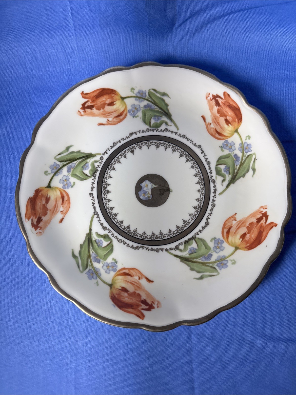 A Hand Painted Porcelain Plate Featuring Tulips And Forget-Me-Nots