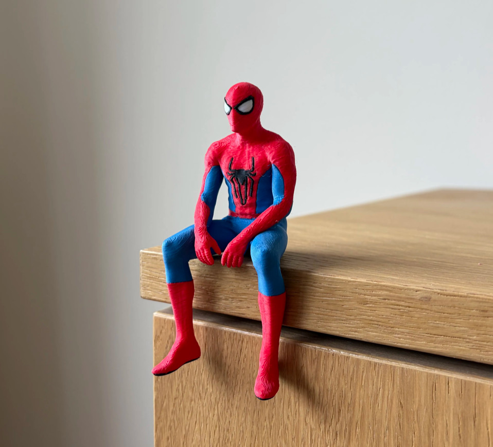 Spiderman Seated Cloak Statue Figurine, sitting on a shelf
