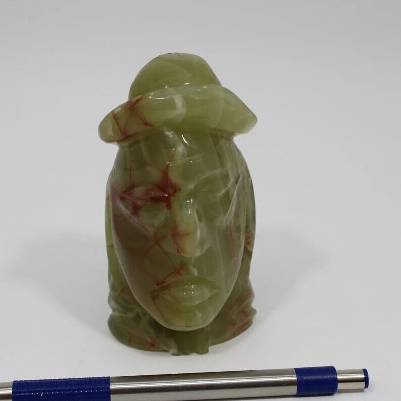 This vintage totem carved jade figurine depicts a Native head/face with a hat