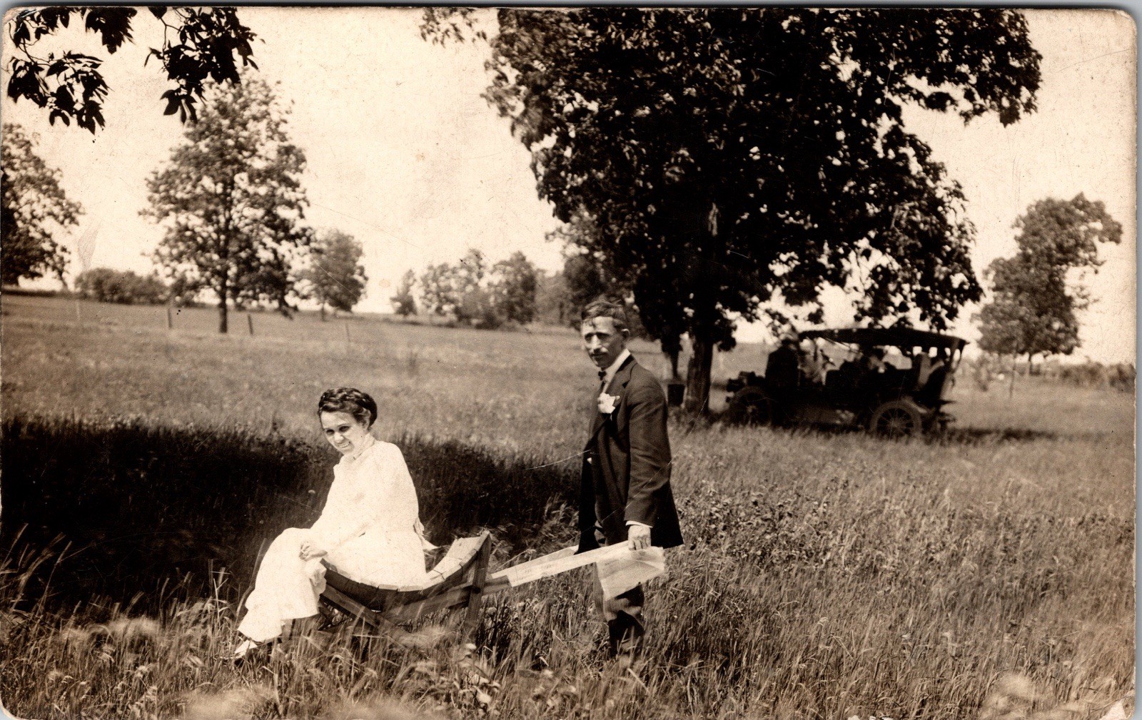Postcard Real Photo RPPC Man and Woman in Grass Field with Old Car