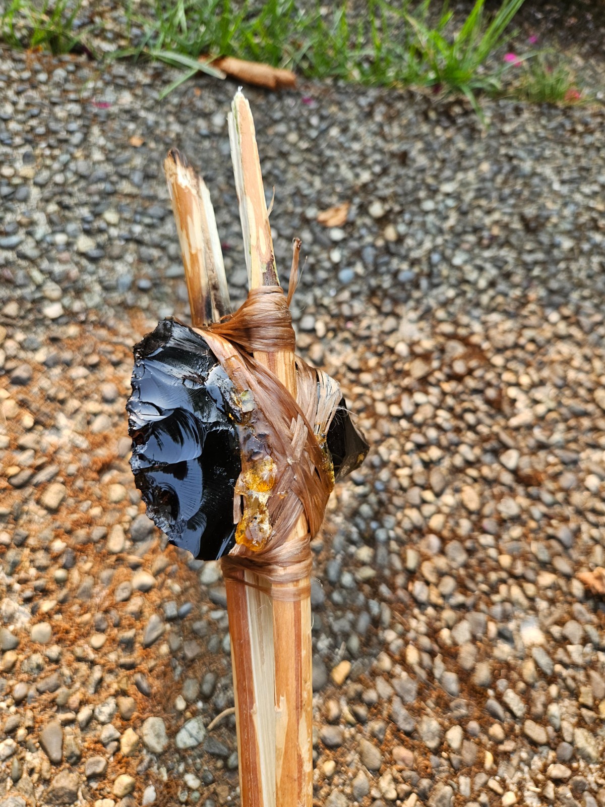 about 4inch obsidian axe with a handle that is about 2 feet