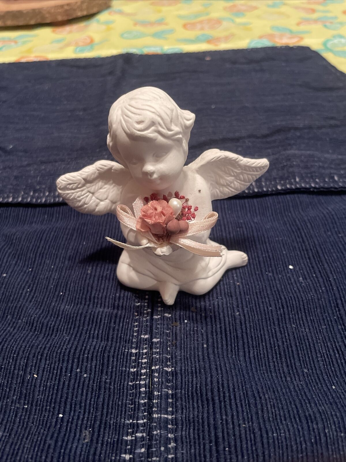  Angel Figurine / Sitting, holding flowers. Pre-owned