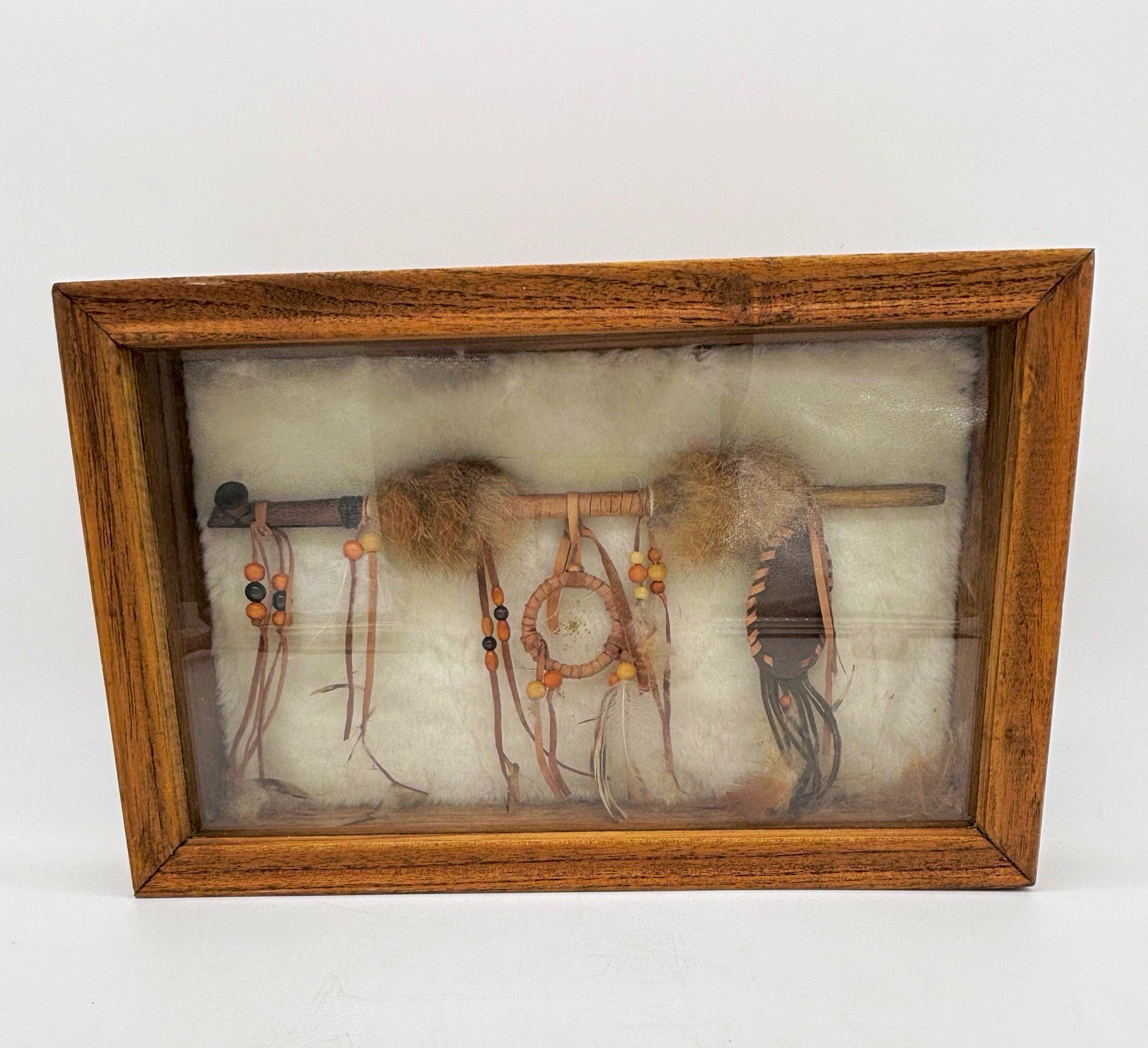 Native American peace pipe with a small dreamcatcher in a wooden shadow box