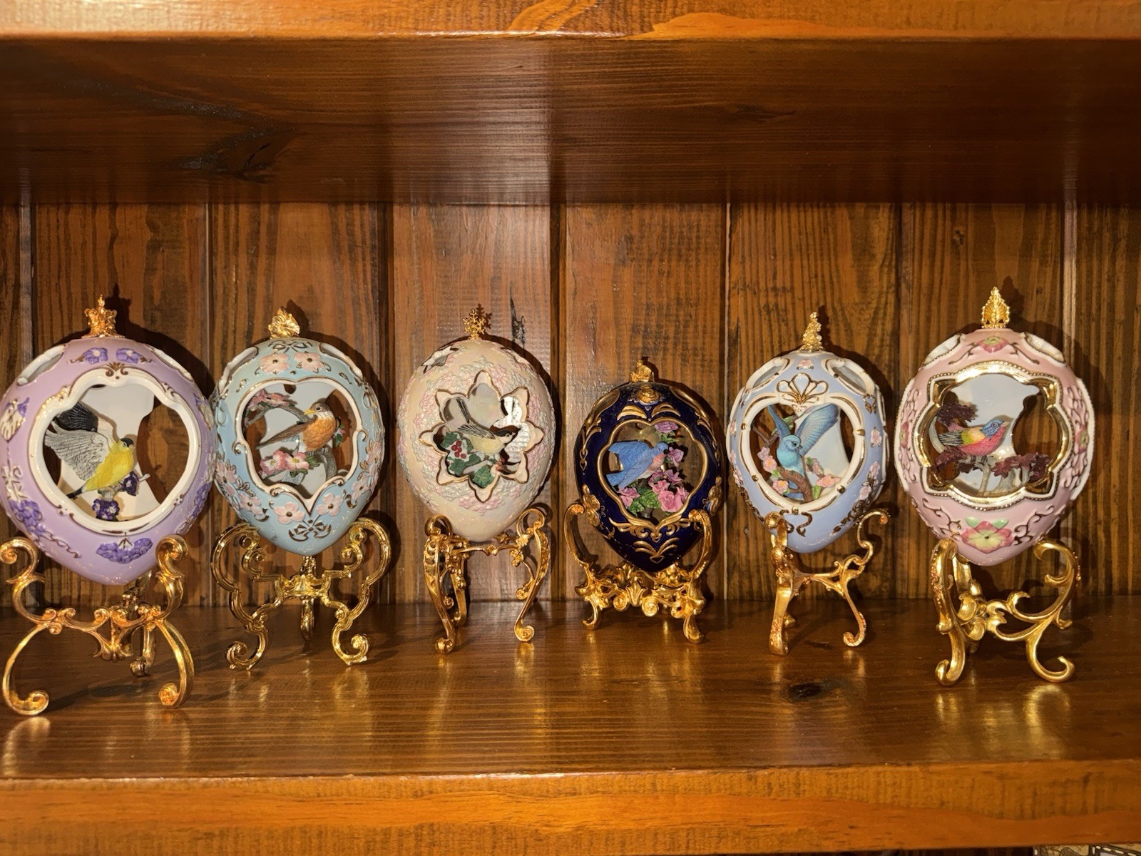 Set of six Fabergé-style porcelain eggs, each with a hand-painted 3D songbird
