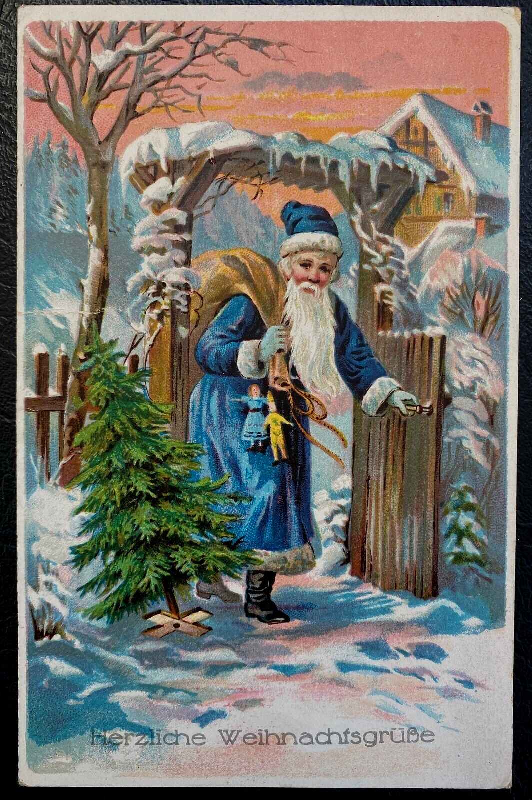 Blue Robe Santa Claus at Gate~in Snow w. Tree~Sack~1910~Christmas Postcard~k280