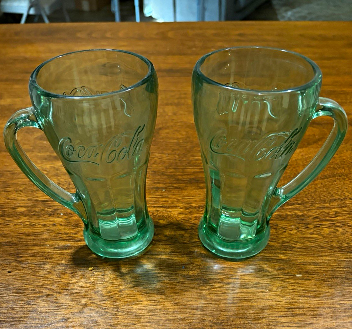 Coca-Cola Set of 2 Embossed Green Glass Mugs w/Handles circa 1970’s-1980’s.