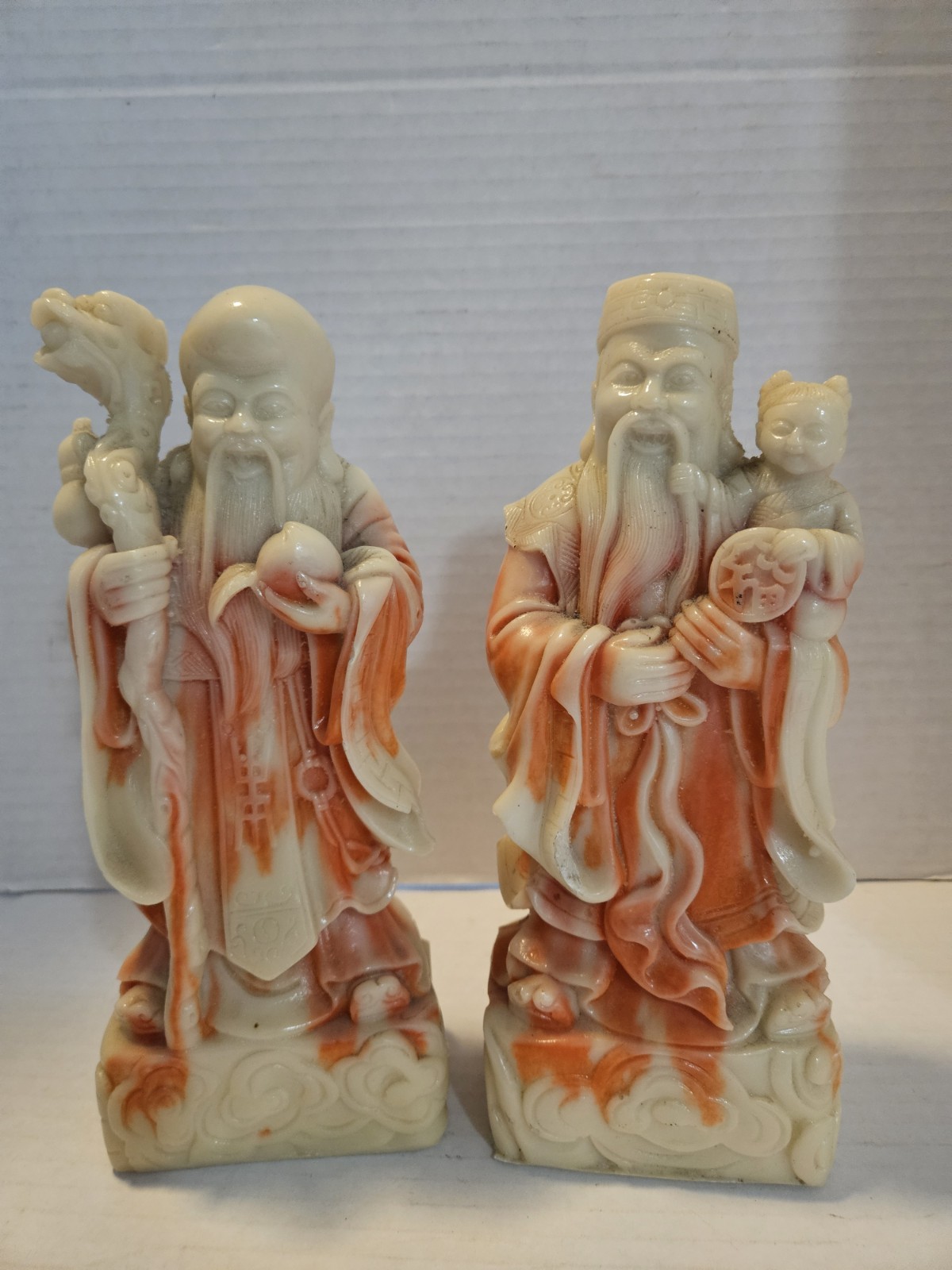 a pair of Chinese carved stone or resin figures depicting the Sanxing (the three