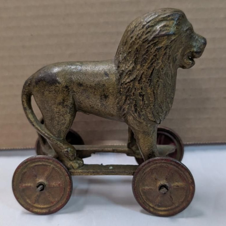 AC Williams cast iron lion coin bank on wheels 1920s