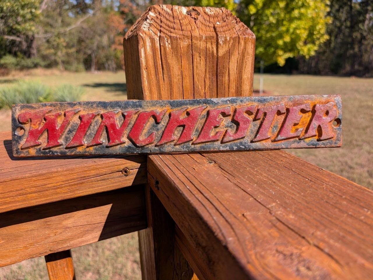 CAST IRON WINCHESTER GUNS RIFLE METAL PLAQUE SIGN RED LETTERS BLACK BACKGROUND
