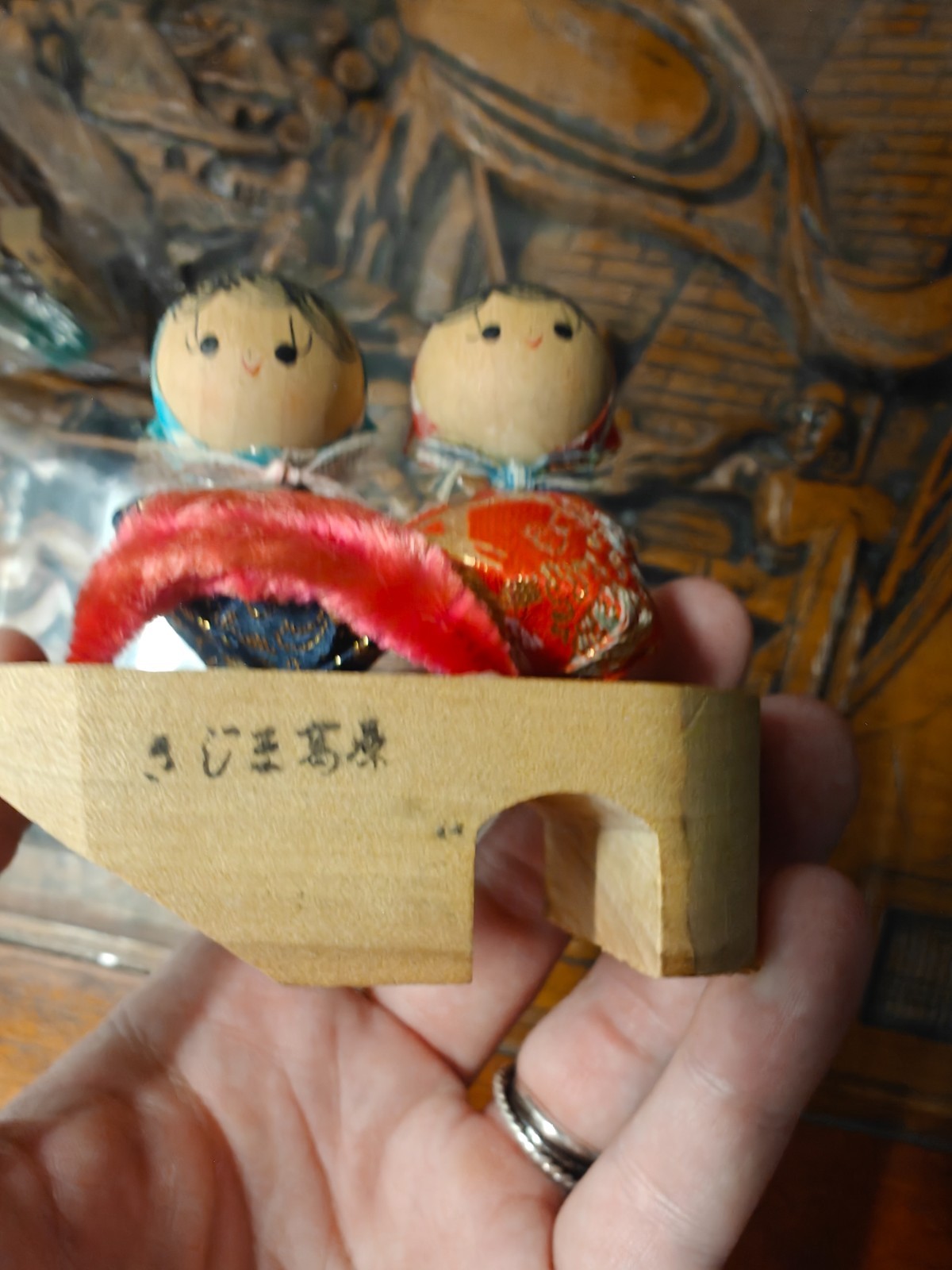 Japanese wooden Kokeshi dolls mounted on a wooden geta sandal base.