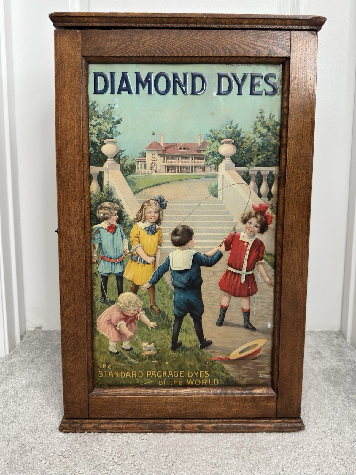 Antique Diamond Dyes Oak Store Cabinet Children Jumping Rope Litho Tin Front