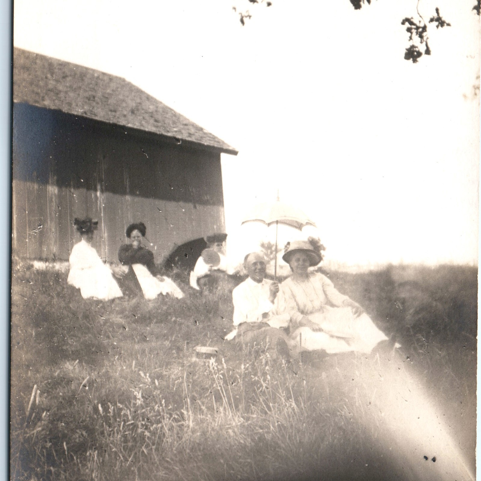 c1910s Outdoor Picnic RPPC Postcard People On Grass Barn Parasol Sun Umbrella