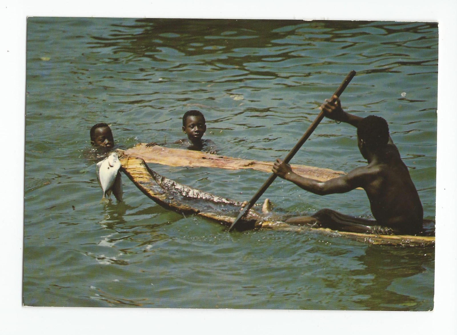 Postcard: Republic of Ivory Coast, Africa - young boys fishing; dugout boat