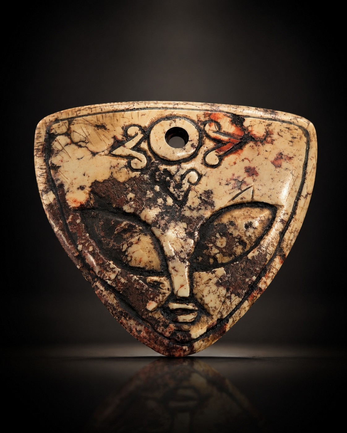 Triangular Carved Stone Pendant with Face Design