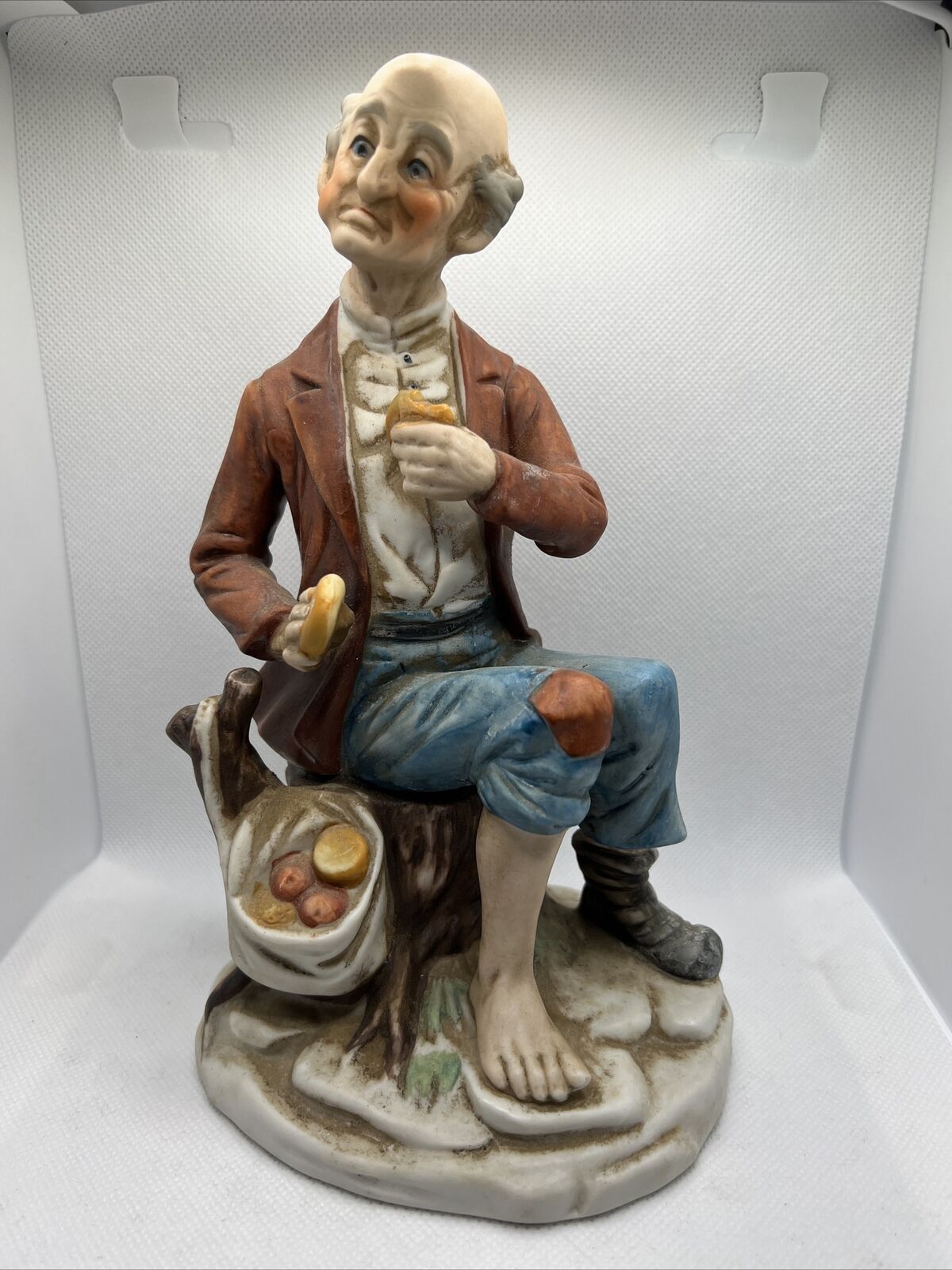 Vintage Porcelain figurine Of a Old sad Poor man eating some veggies, One shoe