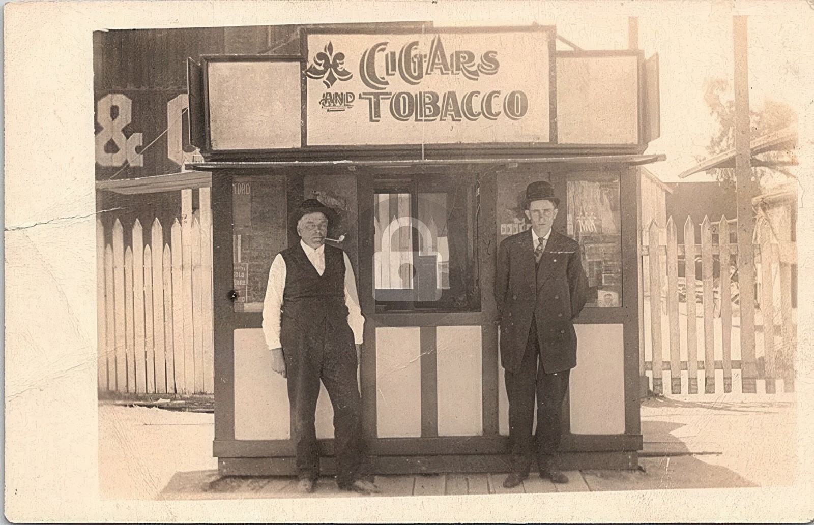 Two Men Posing in Front of Tobacco & Cigar Stand 1900s RPPC Photo Postcard COPY