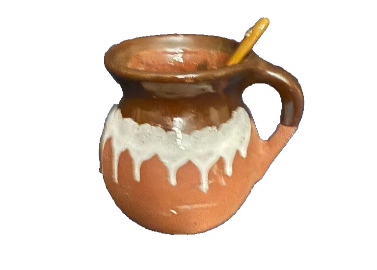 Mi Patria Brown Clay Mug, likely handmade and handpainted with spoon