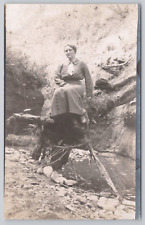 Postcard Woman Sitting on Tree Branch in Front of Stream RPPC picture