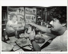 1989 Press Photo Penny Boothe serves a beer to Pat Comiskey at Tark's Restaurant picture