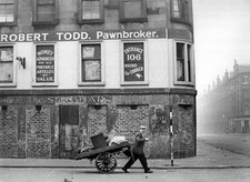 Man pulling a hand cart past a closed down pawnbroker's shop Gorba- Old Photo picture