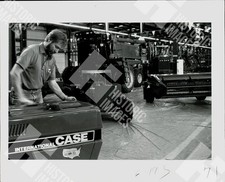 1971 Man inspecting an International Case tractor in a factory setting picture