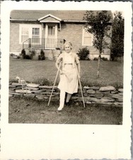 1950s Elderly Woman with Leg Cast Crutches at Brick Home Stone Wall Photograph picture
