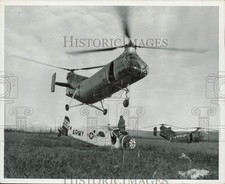 1957 Press Photo A H-21B helicopter lifted a small Army plane in the field picture
