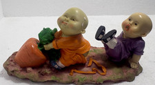 chinnese shaolin monk boys figurine pulling a daikon radish picture