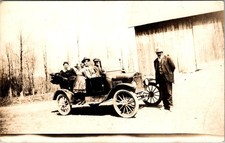 The postcard is an original real photo postcard of a vintage car and family . picture