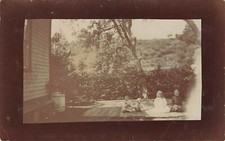 CHILDREN ON WOOD DECK WITH US FLAG IN BACKGROUND REAL PHOTO POSTCARD 1910s RPPC picture