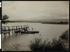 Man In A Boat Near A Dock On Laguna Granda Or College Lake In Wat - Old Photo picture