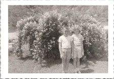 Two Smiling Children by Flower Bush, 1950s Deckle Edge Snapshot Photo picture