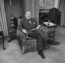 British writer W Somerset Maugham sitting in an armchair with a bo- Old Photo picture