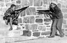 Two young boys playing along a wall carrying rifles 1960 Old Photo picture