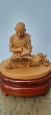 Buddhist Monk Statue reading meditating on a wooden pedestal. Tea set picture