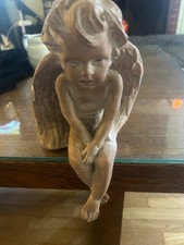Cherub or angel figurine sitting on the edge picture