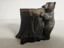 Bronze Grizzly Bear Getting In A Tree Stump picture