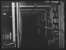 Photo:Library Interior 1940s Man and Woman Browsing Books Shelves picture