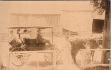 This vintage postcard features a horse and buggy from the early 20th century . picture