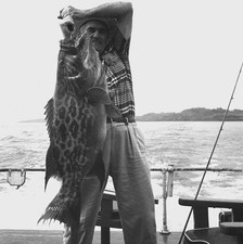 Joe Brooks stands a fishing boat holding a large grouper caught ne- Old Photo picture