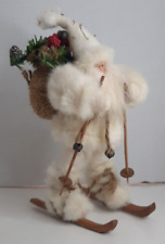 Santa on wooden skis all bundled in fur with his sack on his back.he stands 9   picture